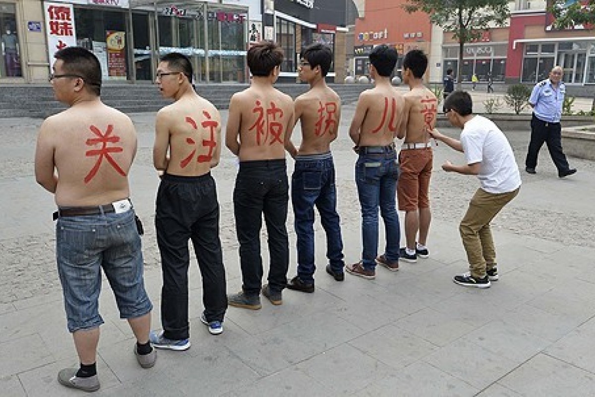 Thanh niên Trung Quốc viết khẩu hiệu lên lưng, phản đối nạn buôn phụ nữ và trẻ em (ảnh: SCMP)