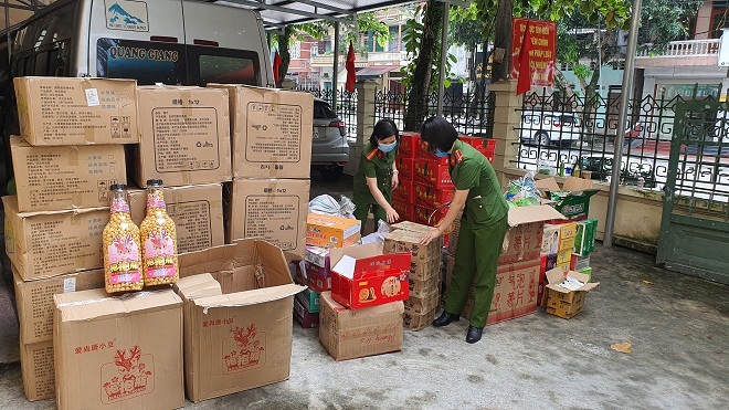 Tổ công tác của Công an thành phố Hà Giang đã phát hiện và thu giữ lô hàng hóa là thực phẩm trong đó có bỏng ngô đóng chai không rõ nguồn gốc, không có hóa đơn chứng từ. Ảnh: Diệu Loan.