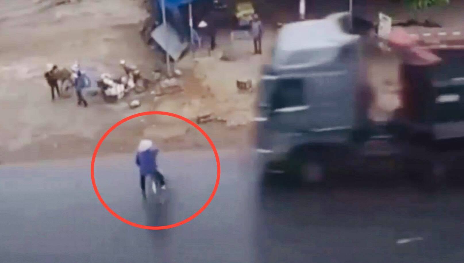 Người phụ đi xe đạp nhảy xuống xe bẻ lái sang trái để tránh bị ô tô tải tông.