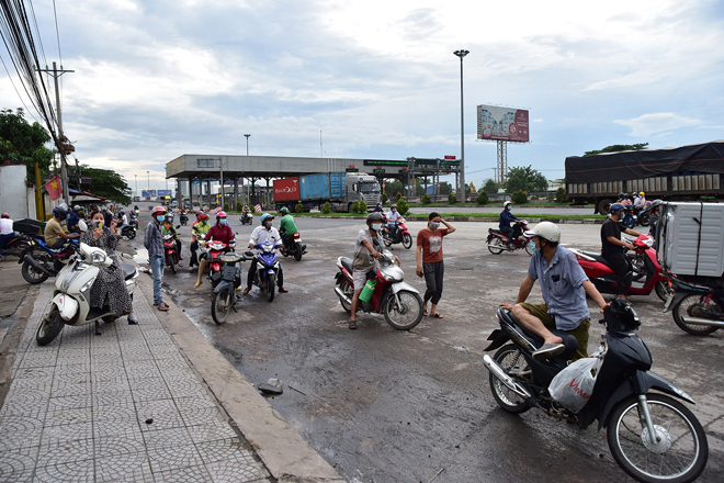 Tại chốt kiểm tra giấy xét nghiệm COVID-19 này, những người chạy xe máy qua đây không có giấy được hướng dẫn quay xe trở lại. Nhiều người không có giấy&nbsp;“thông hành”&nbsp;đành quay xe trở lại nên đứng lại khá đông bên chốt để theo dõi tình hình.