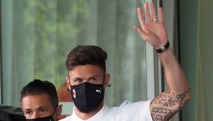 Giroud đeo khẩu trang đen in logo của CLB AC Milan khi vừa đặt chân đến Italia hôm qua