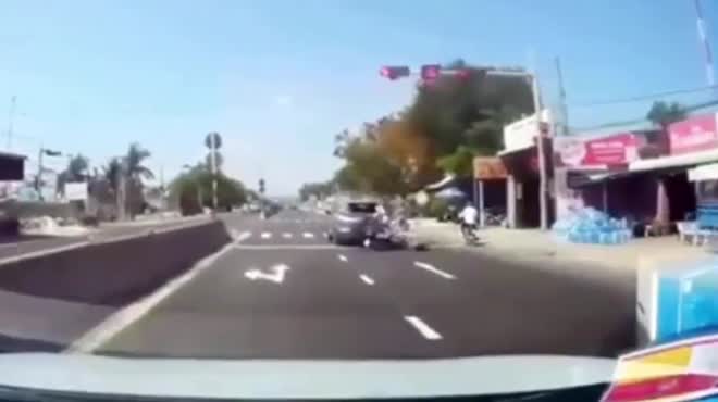 Xe máy tông ô tô đang dừng chờ đèn đỏ.