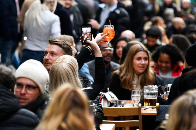 Người dân Anh ăn uống trên đường phố thủ đô London ngày 19-7, sau khi lệnh mở cửa lại nền kinh tế có hiệu lực. Ảnh: AP