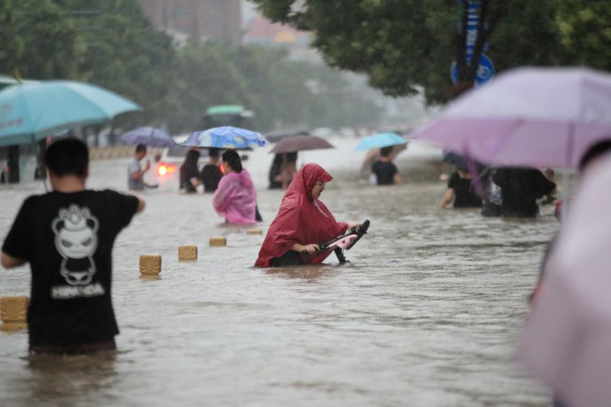 Người dân di chuyển khi nước lũ ngập ngang người ở thành phố Trịnh Châu, tỉnh Hà Nam, Trung Quốc hôm 20/7. Ảnh: Reuters