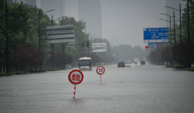 Biển báo nguy hiểm trên đường phố ngập nước ở TP Trịnh Châu, Hà Nam, Trung Quốc. Ảnh: TÂN HOA XÃ