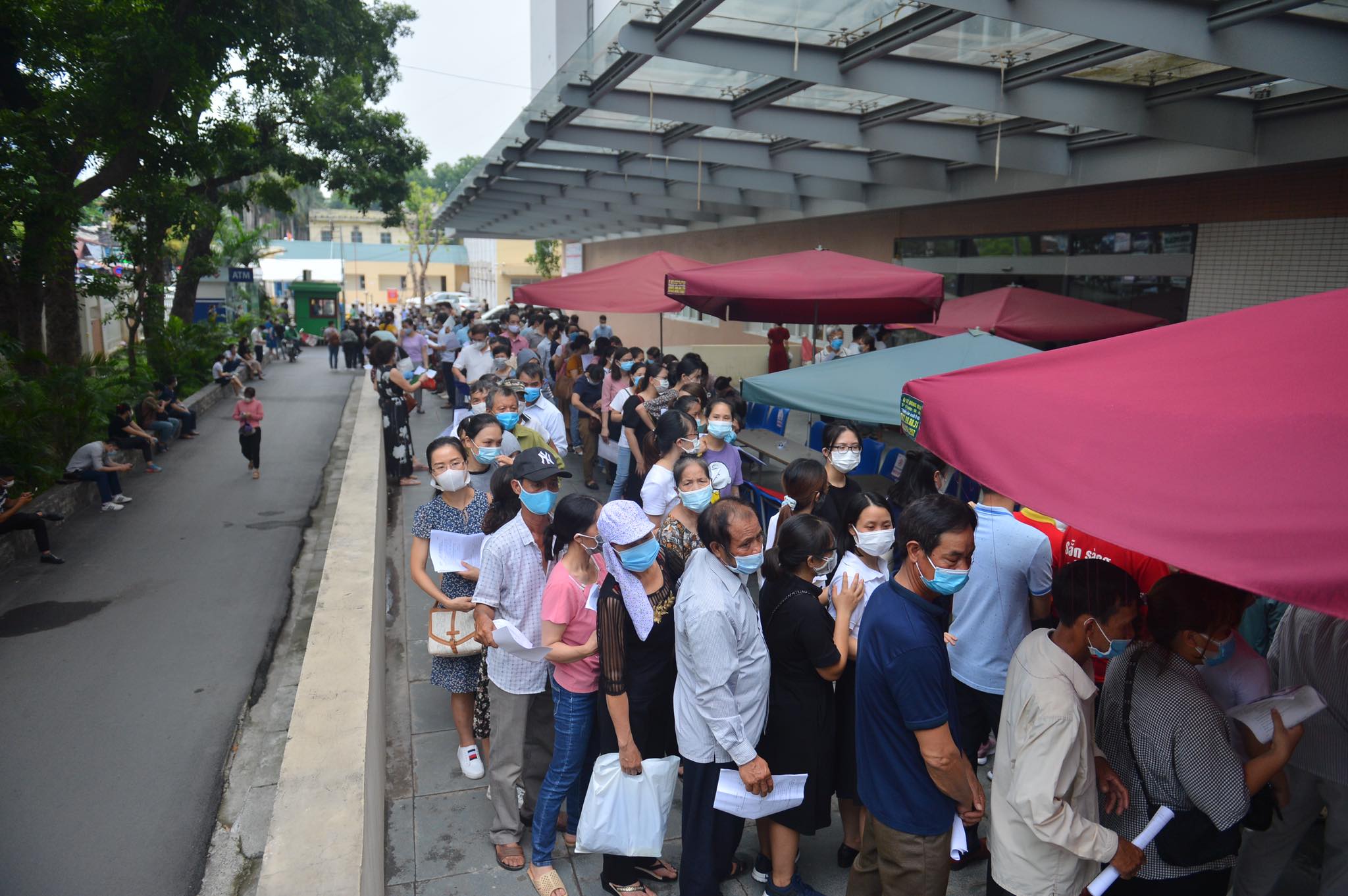 Dù được đo thân nhiệt từ cổng, phát tờ khai y tế, song người dân lại không giữ khoảng cách an toàn 2m khi đứng chờ tiêm.