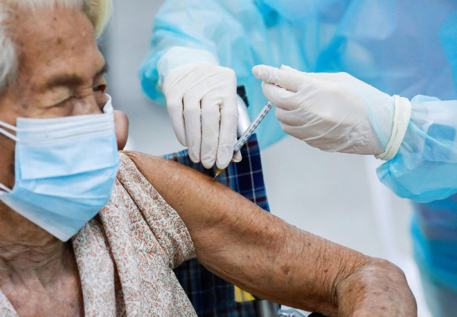 Một cụ bà được tiêm vắc-xin Covid-19 tại Trung tâm Tiêm chủng trung ương ở thủ đô Bangkok - Thái Lan hôm 26-7. Ảnh: REUTERS