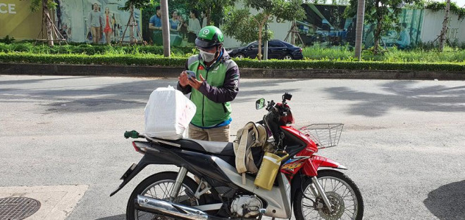 Một shipper đi giao hàng vào sáng 28-7. Ảnh: Lam Giang