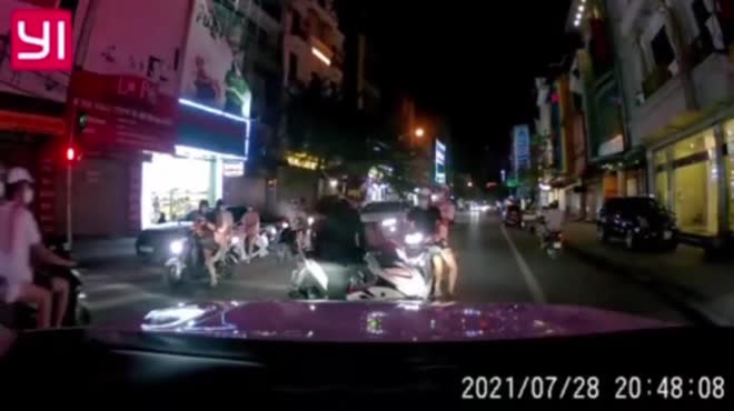Hai thanh niên dừng xe trên làn đường ngược chiều vì vượt đèn đỏ bất thành.