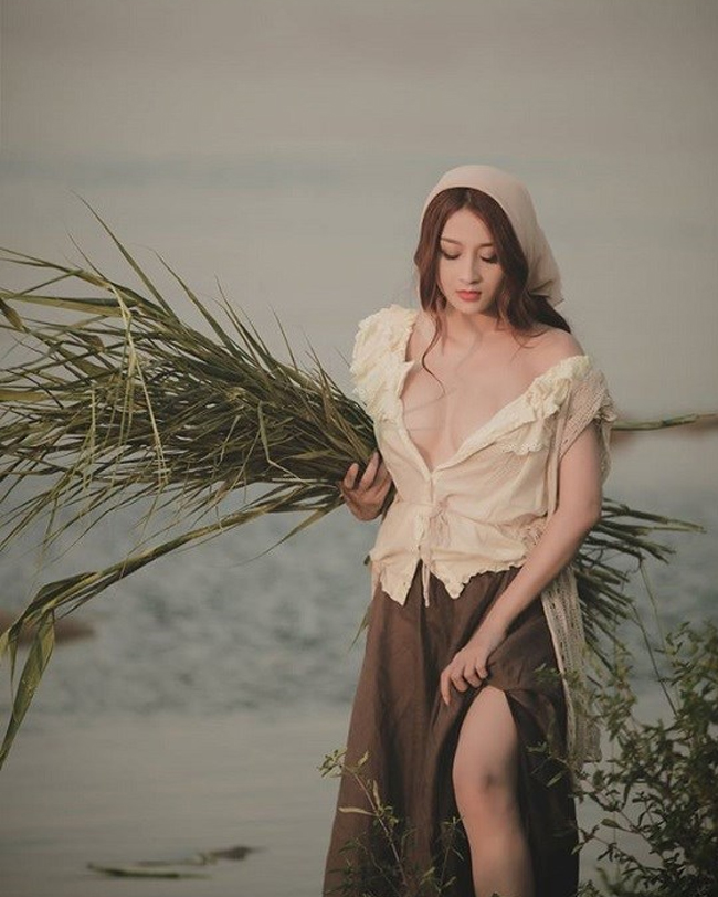Hóa thân thành "cô thôn nữ gợi tình" giữa cánh đồng lúa, hot girl Việt mặc áo trễ nải, tôn vòng 1 đầy đặn kết hợp chân váy xẻ cao.
