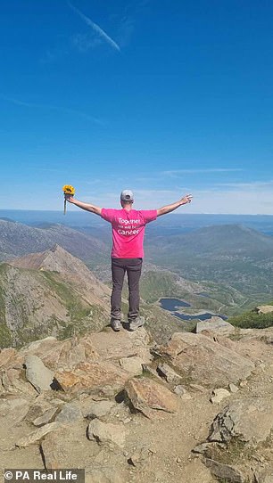 Ryan&nbsp;cầm một bông hoa hướng dương trên đỉnh Scafell Pike, ở Lake District và đỉnh Snowdon, Wales