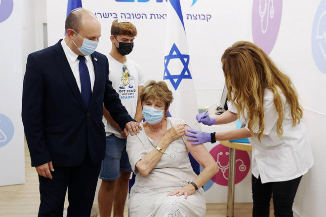Thủ tướng Israel Naftali Bennett&nbsp;(trái)&nbsp;đưa mẹ là bà Mirna Bennett&nbsp;(giữa)&nbsp;tiêm mũi vaccine ngừa COVID-19 thứ ba hôm 3-8. Ảnh: REUTERS