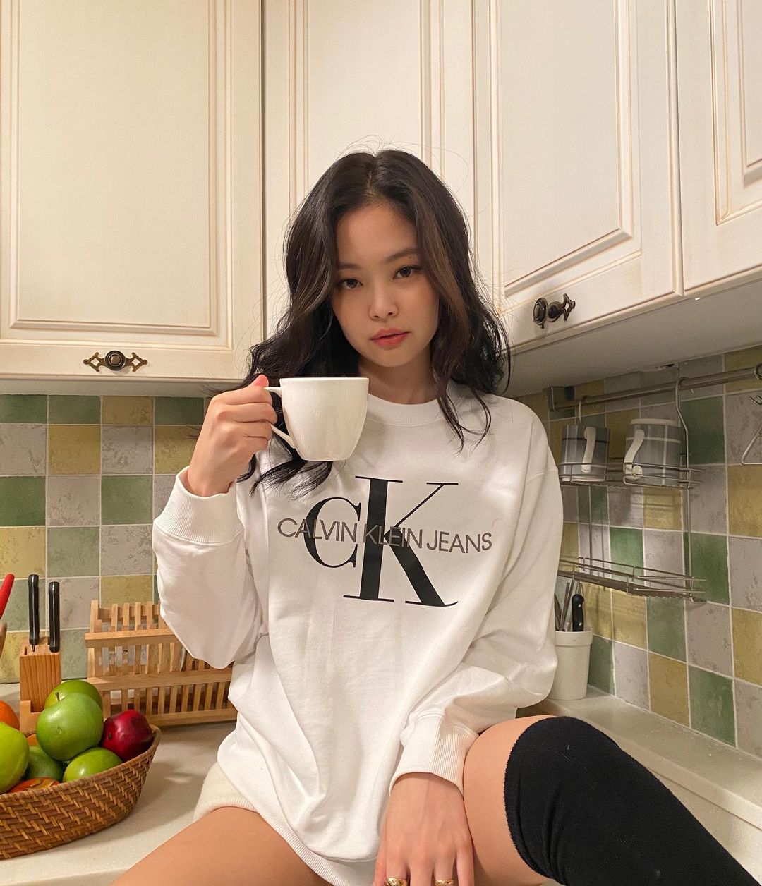 Jennie (Black Pink) thời thượng khi mặc sweater dáng rộng kết hợp với tất đùi.