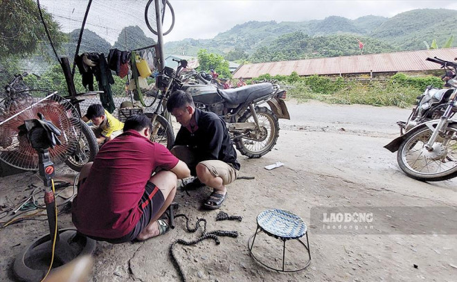 Anh Thào A Phổng (áo đen) làm ở quán sửa xe máy gần nhà cùng những người trong gia đình. Ảnh: Văn Thành Chương/Lao Động.
