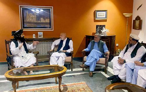 Cựu Tổng thống Afghanistan Hamid Karzai (thứ hai từ trái sang) trao đổi với một đại diện phong trào Taliban trong bức ảnh được đăng tải hôm 19-8 Ảnh: REUTERS