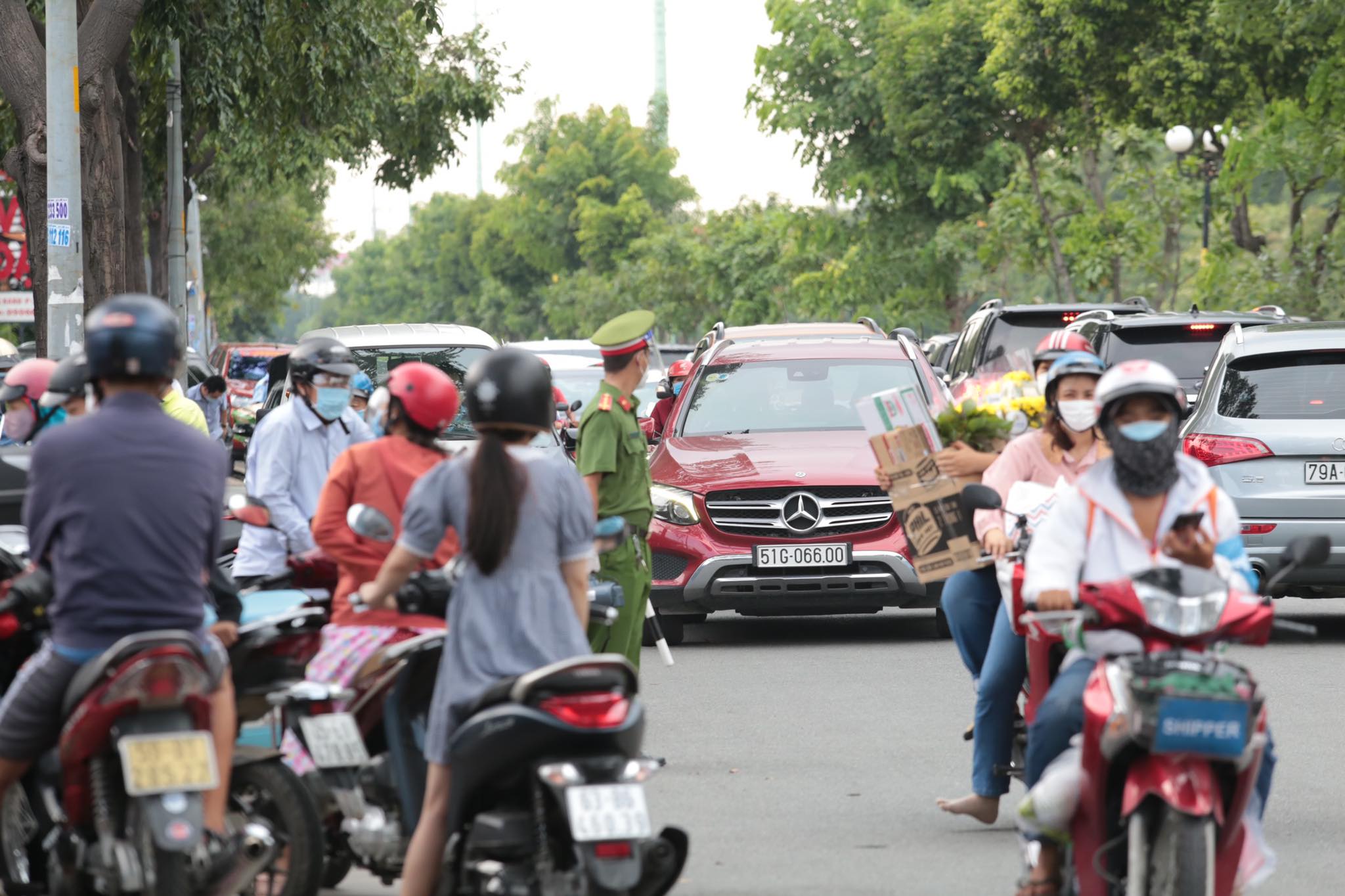 Hàng trăm xe máy, ôtô đứng chờ trước cổng vào siêu thị MM Mega Market An Phú. Nhiều người cho biết họ chờ hơn 30 phút nhưng vẫn chưa gửi xe được do bãi xe của siêu thị đã kín chỗ.