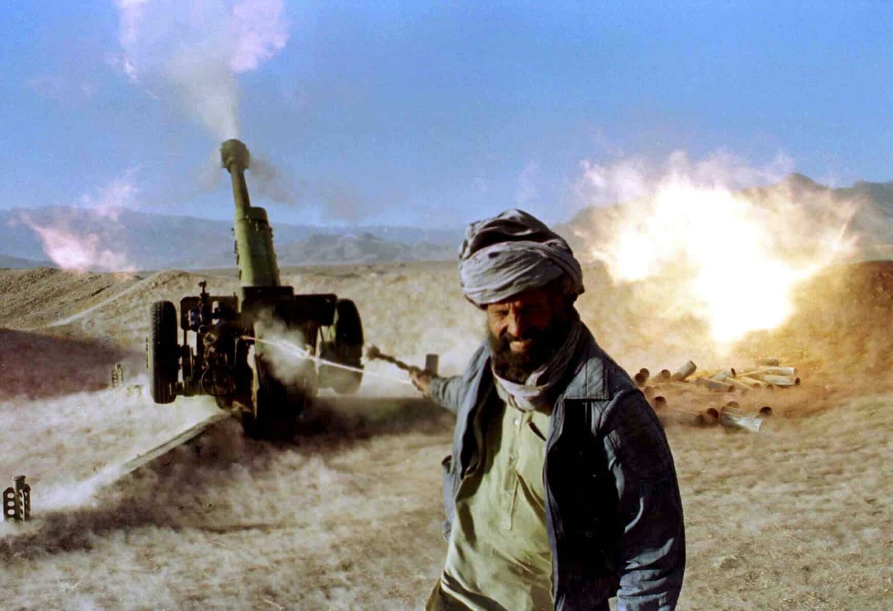 Một tay súng Taliban giật dây kích nổ khẩu pháo của Liên Xô ở Afghanistan năm 1996. Ảnh: Reuters