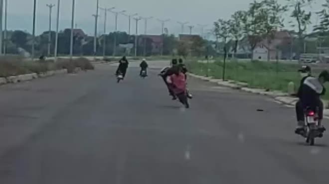 Nhóm thanh niên không đội mũ bảo hiểm thi nhau bốc đầu xe, đánh võng trên đường.