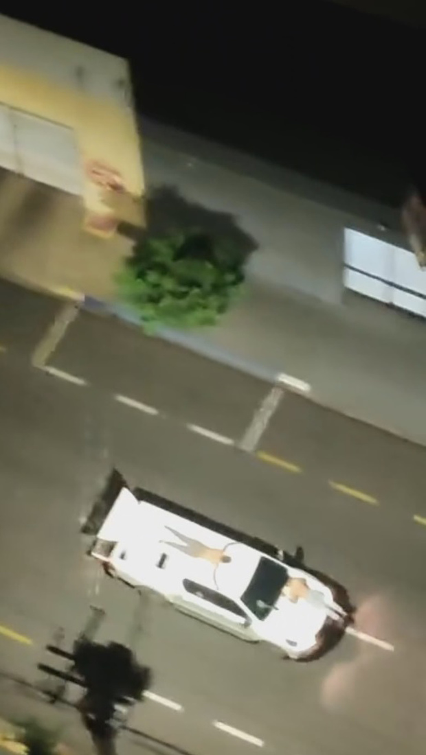 Các con tin bị bắt bám ngoài ô tô làm "lá chắn sống" cho nhóm cướp ở Brazil. Ảnh: Newsflash