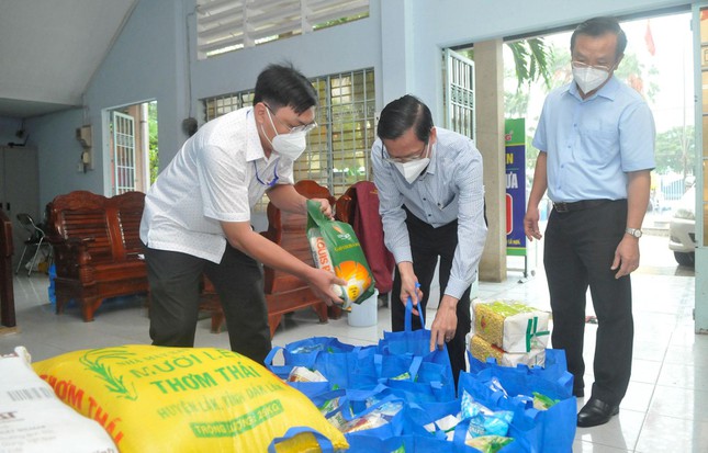 Chủ tịch UBND TPHCM Phan Văn Mãi (giữa) kiểm tra các túi an sinh cho người dân