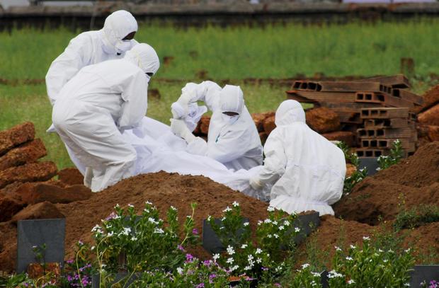 Các nhân viên y tế chôn cất thi thể của 1 bệnh nhân tử vong vì virus Nipah ở bang Kerala vào ngày 24-5-2018. Ảnh: AP