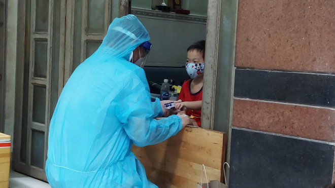Nhân viên Trạm Y tế phường 8, quận 11, TP HCM thăm khám cho F0 cách ly tại nhà.