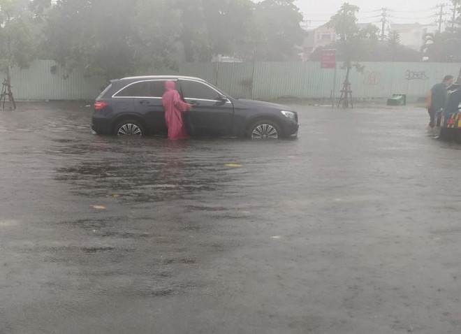 Nước ngập lênh láng trên đường Phạm Văn Đồng khiến nhiều ô tô chết máy. Ảnh: Tấn Việt