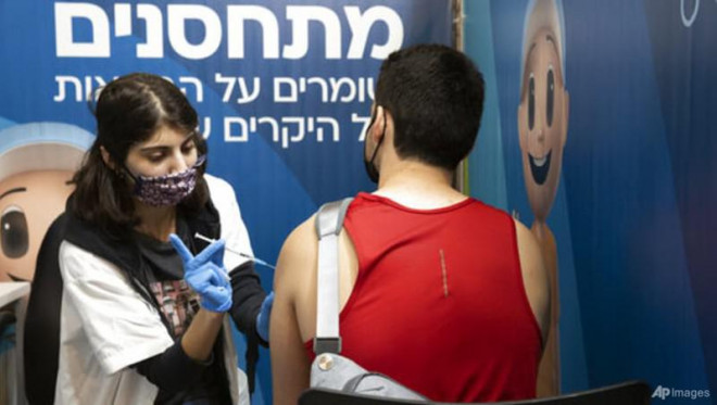 Nhân viên y tế tiêm liều vaccine ngừa COVID-19 thứ ba cho người dân ở Israel. Ảnh: AP