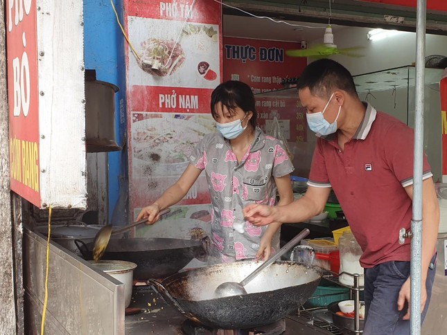 Trên phố Ngô Xuân Quảng (Trâu Quỳ, Gia Lâm), hai vợ chồng chủ quán phở gà tíu tít phục vụ đồ ăn cho 4 khách đang xếp hàng chờ mang về.