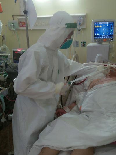 Chiến sĩ Nguyễn Minh Tâm đang hỗ trợ lấy đàm cho bệnh nhân Covid-19 thở máy