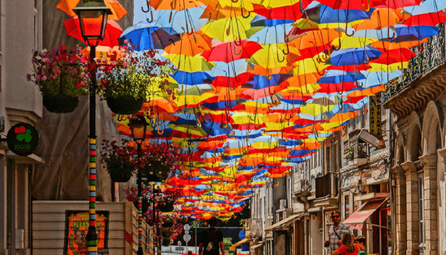 Agueda, Bồ Đào Nha: Những con phố nhỏ hẹp được bao phủ bởi những chiếc ô rực rỡ, vừa giúp du khách thoát khỏi cái nóng, vừa mang lại cho con phố một hình ảnh đầy màu sắc hoàn hảo. Đây nổi tiếng là một trong những con đường đẹp nhất thế giới.
