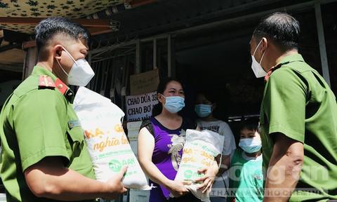 CBCS Công an TPHCM mang gạo, nhu yếu phẩm đến tặng người dân bị ảnh hưởng bởi dịch COVID-19.&nbsp;Ảnh: Đức Nam