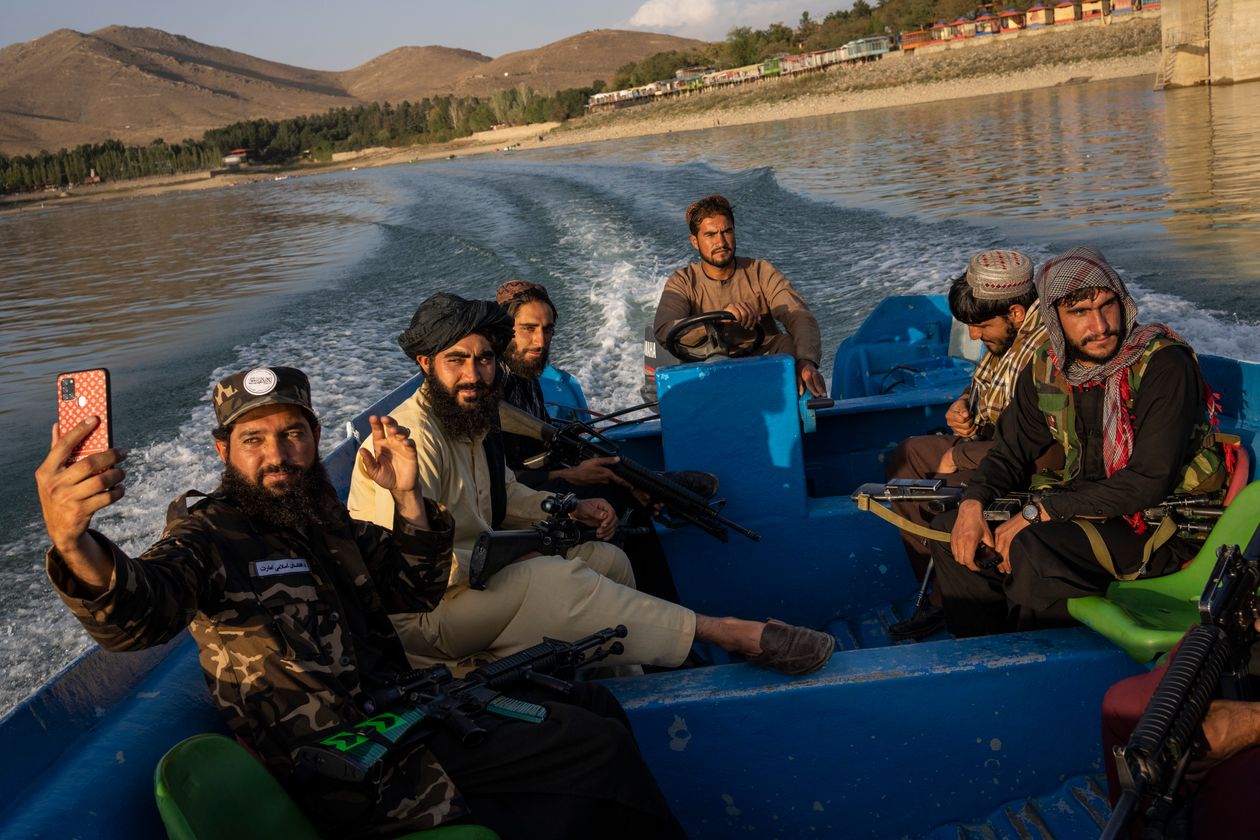 Các tay súng Taliban ngồi thuyền trên một con sông ở ngoại ô Kabul.