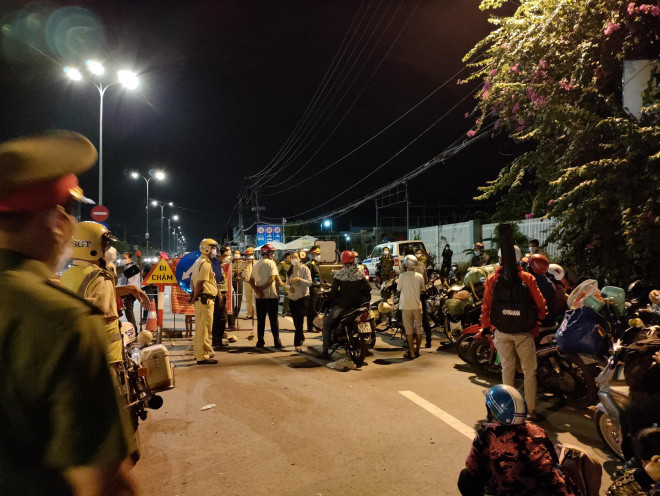 Lực lượng chức năng của huyện Bình Chánh thuyết phục người dân quay trở lại điểm xuất phát nhằm tránh nguy cơ lây nhiễm do tụ tập đông người.