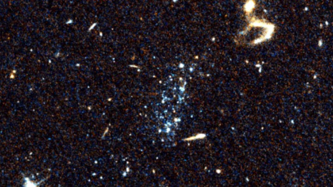 Hình ảnh chụp bởi Kính viễn vọng không gian Hubble của NASA cho thấy các đốm màu xanh lạ hiện diện trên bầu trời, xung quanh là những đốm vật chất nhỏ hơn, li ti, cũng phát ra ánh sáng xanh hoặc trắng - Ảnh: HUBBLE/NASA