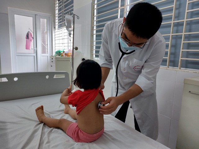 Bác sĩ thăm khám cho một bệnh nhi nhiễm cúm A tại BV Bệnh Nhiệt đới Trung ương. (Ảnh: SKĐS)
