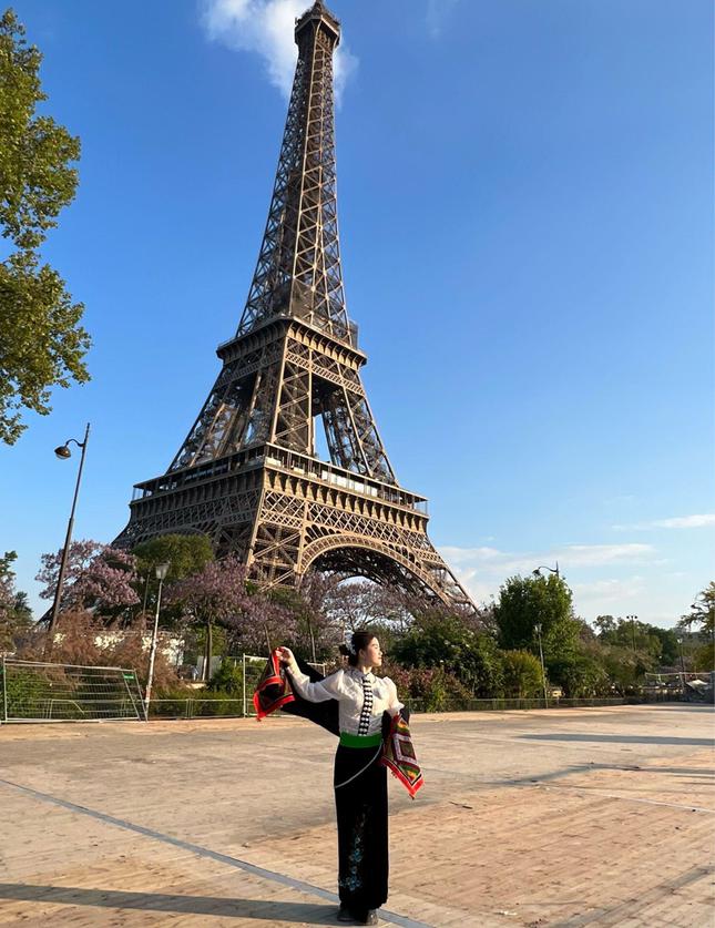 Thùy Dương khoác trên mình trang phục cổ truyền dân tộc Thái dưới chân tháp Eiffel, Paris, Pháp.