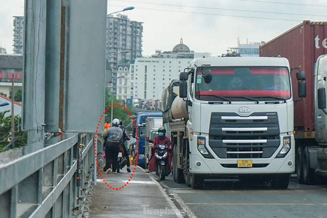 Ngoài ra, hướng từ dưới dạ cầu Phú Mỹ (phía quận 7) lên cầu cũng bị ùn tắc cục bộ, nhiều người đi xe máy phải quay đầu chạy ngược chiều hoặc chạy xe lên hành lang cầu để qua đoạn kẹt.