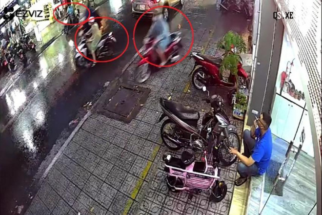 Nhóm trộm có hai thanh niên chạy xe, người ngồi sau chỉ dao vào quán trà sữa đe dọa. Ảnh chụp từ clip