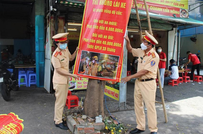 CSGT Bình Thạnh treo băng rôn tuyên truyền an toàn giao thông trước một quán ăn. Ảnh: N.YÊN