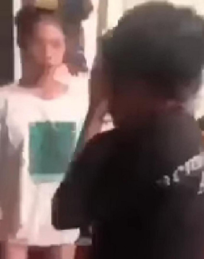 Nữ sinh áo trắng tấn công vào người nữ sinh mặc áo đen. Ảnh cắt từ video clip.