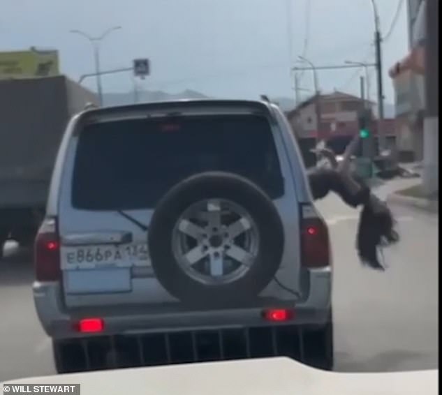 Người phụ nữ ngả người về phía sau ra khỏi cửa sổ của chiếc xe đang di chuyển