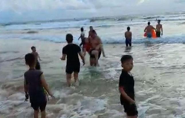 Nhóm tham gia cứu các nạn nhân bị đuối nước đưa vào bờ (ảnh cắt từ clip).