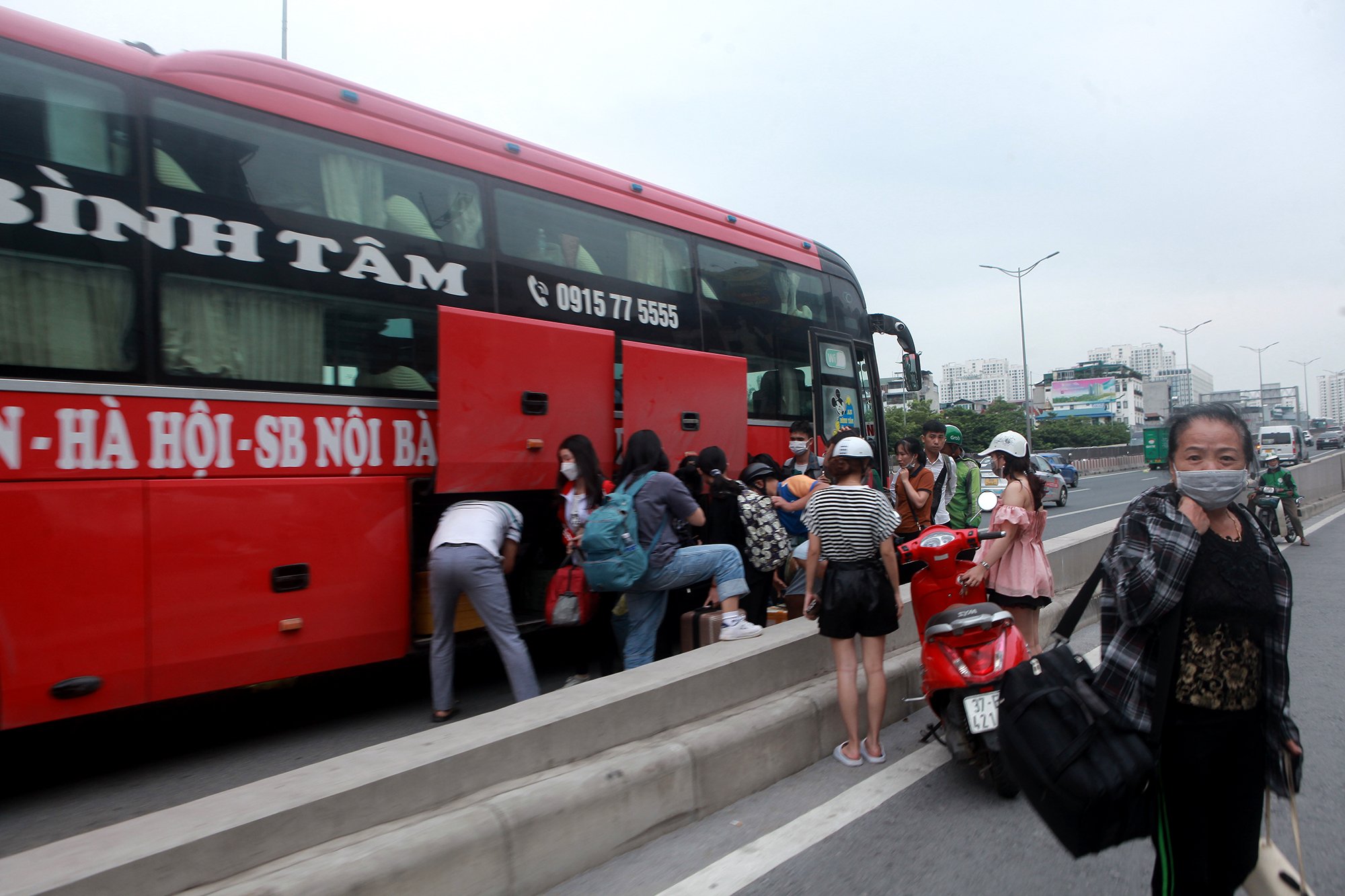 Một xe khách trả khách ngay lối lên đường vành đai 3 hướng Mai Dịch&nbsp;- Nam Thăng Long gây nguy hiểm cho người dân.