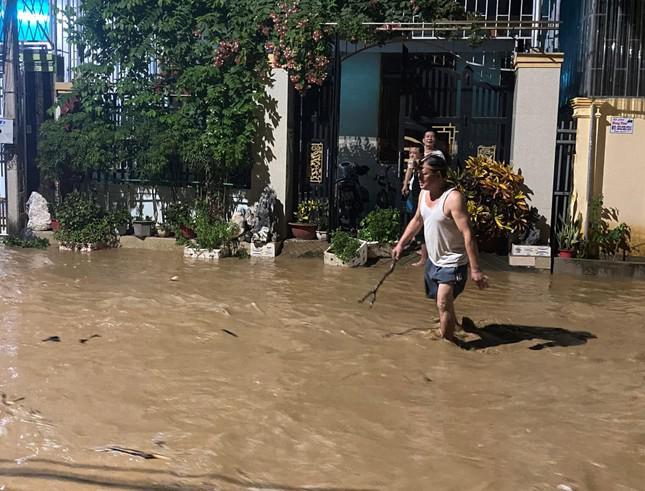 Dòng nước lũ cuồn cuồn, đục ngầu, kéo theo đất đá, cây cối, làm ngập nhà dân ở khu vực thị trấn Mường Xén.