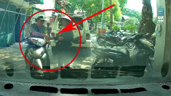 Hình ảnh được camera hành trình của ô tô ghi lại cảnh người đàn ông mặc trang phục giống cán bộ quản lý thị trường nhận vật giống tiền của người bán hàng rong tại quận Hoàn Kiếm, TP Hà Nội