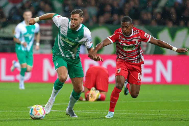 Chơi trên sân nhà và được đánh giá cao hơn nhưng Werder Bremen (áo xanh lá cây) vẫn gặp khó trước Augsburg