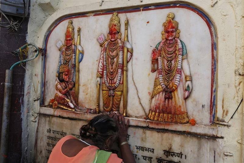 Một người hành hương Ấn Độ chạm tay vào ảnh các vị thần Hindu ở&nbsp;Ayodhya vào năm 2019. Ảnh: AP.