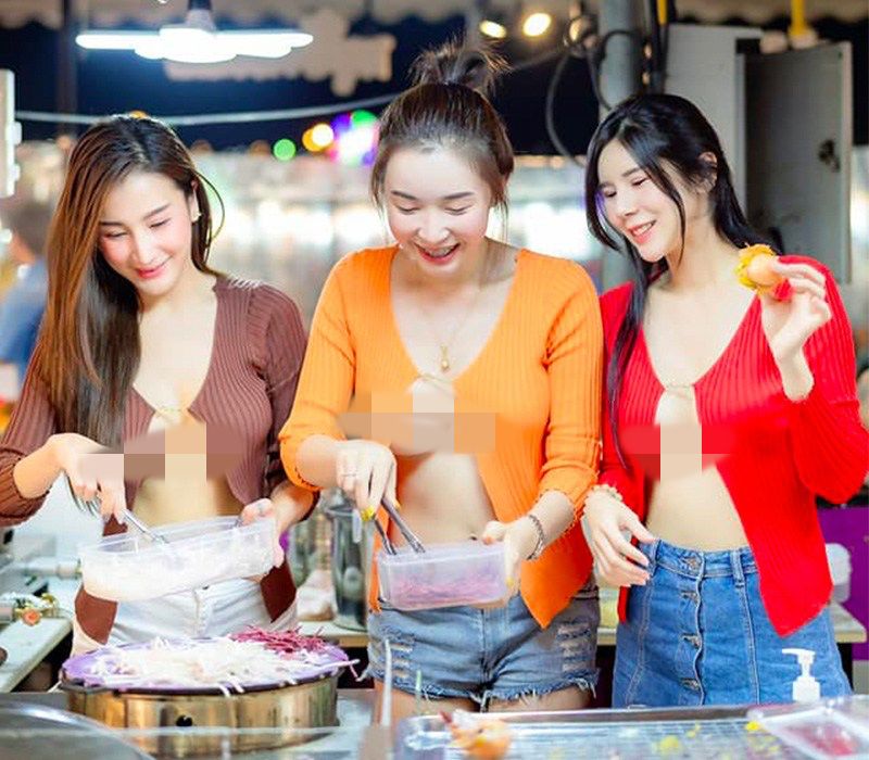 3 cô gái ăn mặc hở hang bán bánh tại một chợ ở Thái Lan