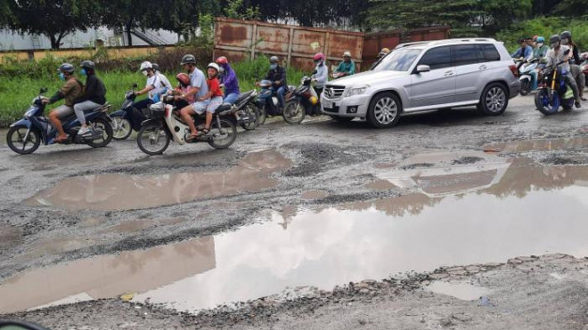 Việc xuất hiện các "ổ voi" trên đường khiến các phương tiện lưu thông khó khăn, phải né tránh để không bị sụp "ổ voi". Ảnh: Quang Phương.